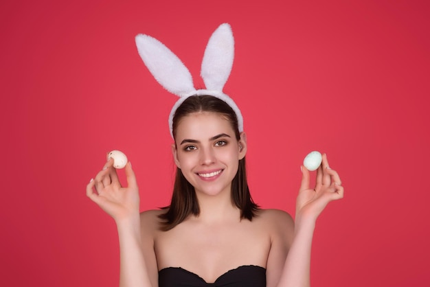 Portret van een vrolijk mooi jong meisje dat Pasen viert geïsoleerd over studio achtergrond Studio foto van een jonge vrouw die bunny oren draagt Feestelijke bunny