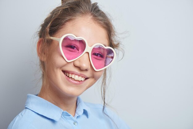 Portret van een vrolijke Aziatische Kazachse jonge vrouw in een stijlvolle bril, gekleed casual glimlachend vrolijk geïsoleerd op een witte achtergrond