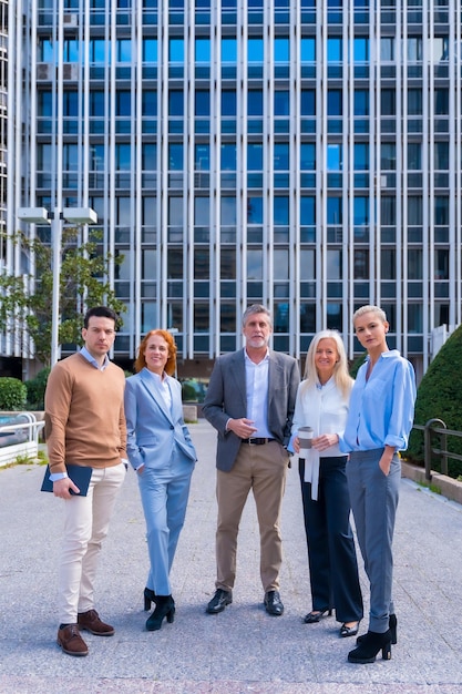 Portret van een vrolijke groep collega's die buiten in een kantoorruimte lopen