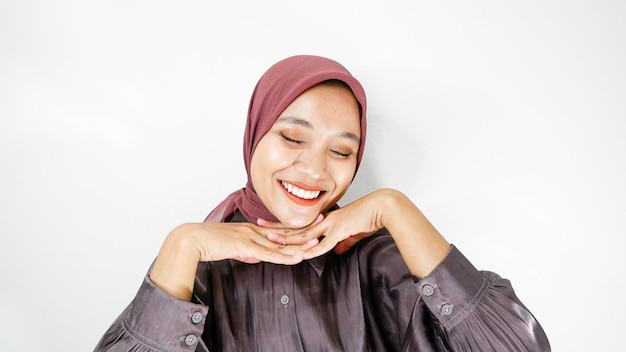 Portret van een vrolijke jonge Aziatische vrouw met een hijab op een witte achtergrond