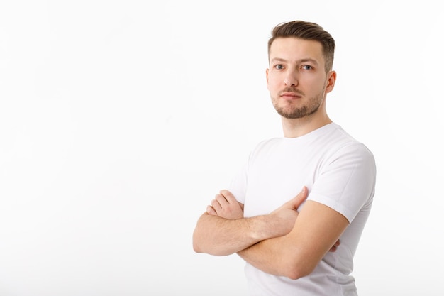 Portret van een vrolijke jonge man in een wit T-shirt op een witte achtergrond De man staat naar de camera te kijken en te glimlachen