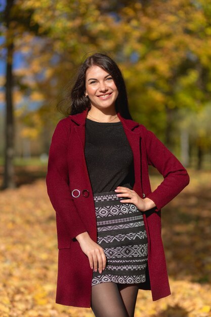 Portret van een vrolijke jonge vrouw die geniet in het herfstpark.