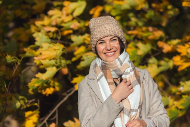 Portret van een vrolijke jonge vrouw die geniet in het herfstpark.