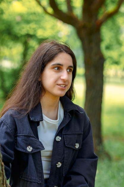 Portret van een vrolijke jonge vrouw met vrolijke emoties op haar gezicht in het lentepark op een zonnige dag