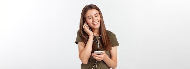 Portret van een vrolijke leuke vrouw die muziek luistert in een koptelefoon en danst geïsoleerd op een witte achterkant