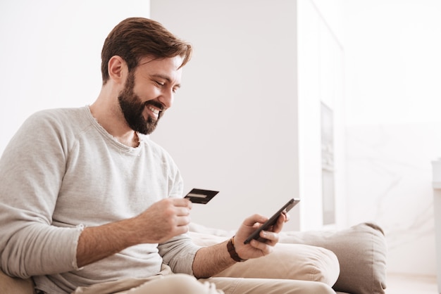 Portret van een vrolijke man online winkelen