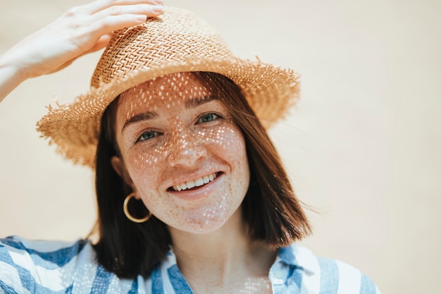 Portret van een vrolijke vrouw die een strohoed draagt