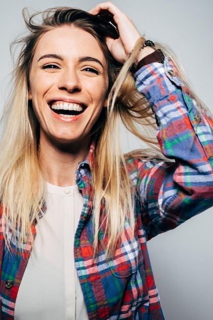 Foto portret van een vrolijke vrouw die tegen de muur lacht