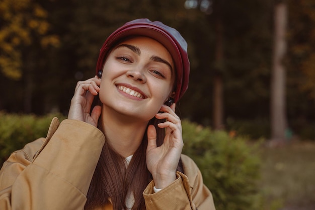 Portret van een vrolijke vrouw in draadloze oortelefoons die naar muziek luistert en geniet van melodie