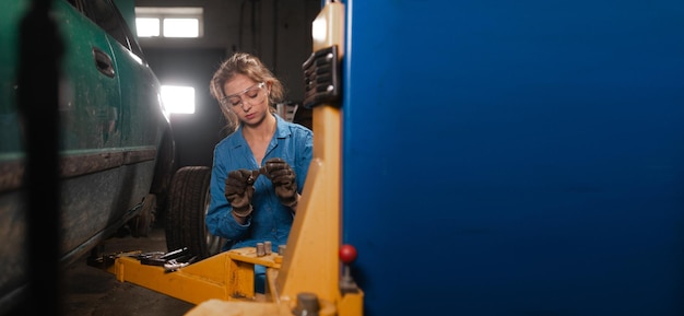 Portret van een vrouw automonteur in werkende overall en bril Baner