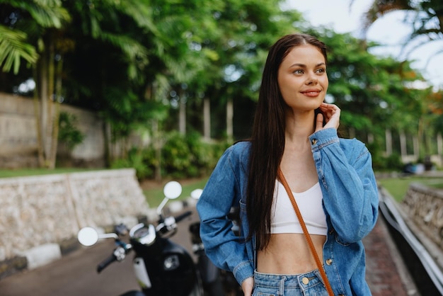 Portret van een vrouw brunette glimlach met tanden buiten lopen tegen een achtergrond van palmbomen in de tropen zomervakanties en openluchtrecreatie de zorgeloze levensstijl van een freelance student