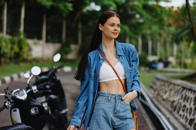 Portret van een vrouw brunette glimlach met tanden buiten lopen tegen een achtergrond van palmbomen in de tropen zomervakanties en openluchtrecreatie de zorgeloze levensstijl van een freelance student