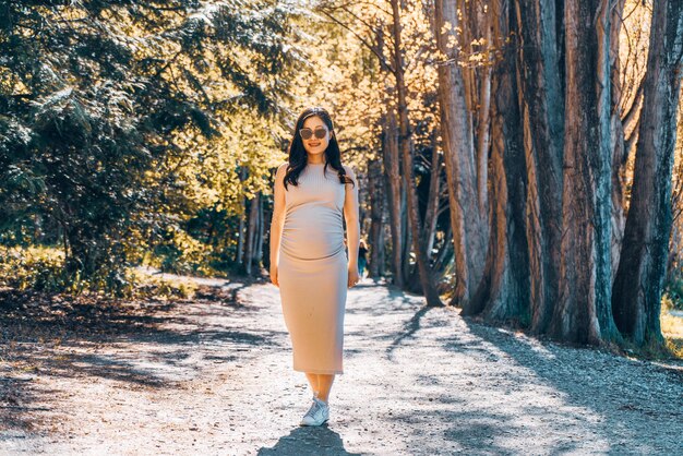 Portret van een vrouw die bij een boom in het bos staat