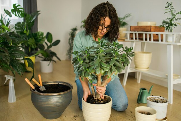 Foto portret van een vrouw die bij een potplant zit