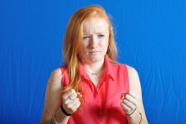 Foto portret van een vrouw die drinkt tegen een blauwe achtergrond