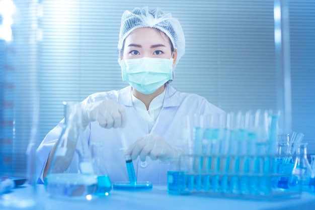 Portret van een vrouw die een experiment doet op een tafel in het laboratorium