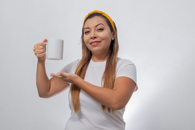 Portret van een vrouw die een witte kop toont Persoon die een kop koffie vasthoudt op witte achtergrond