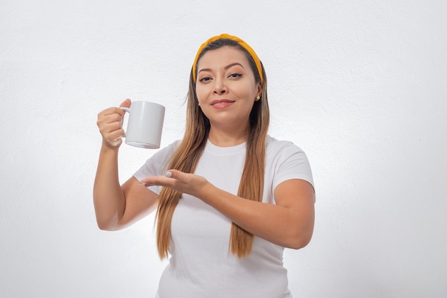 Portret van een vrouw die een witte kop toont Persoon die een kop koffie vasthoudt op witte achtergrond