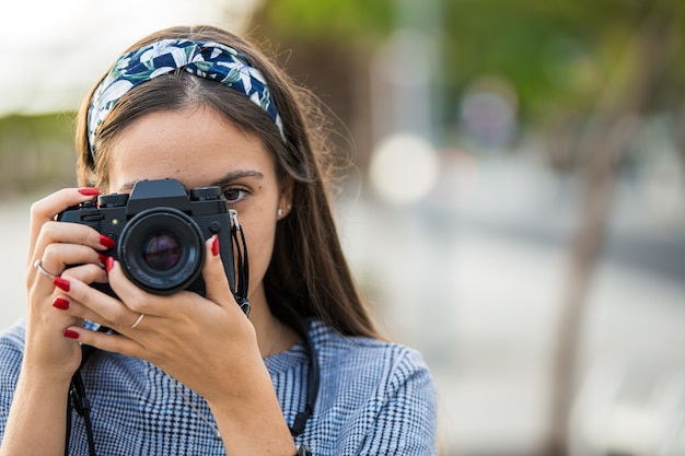 Portret van een vrouw die foto's met haar camera neemt