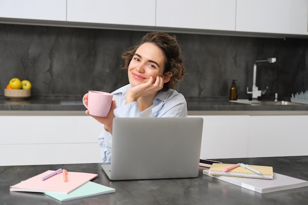 Portret van een vrouw die jarenlang online studeert, kijkt naar een cursus internetwerken op een laptop vanuit haar huis