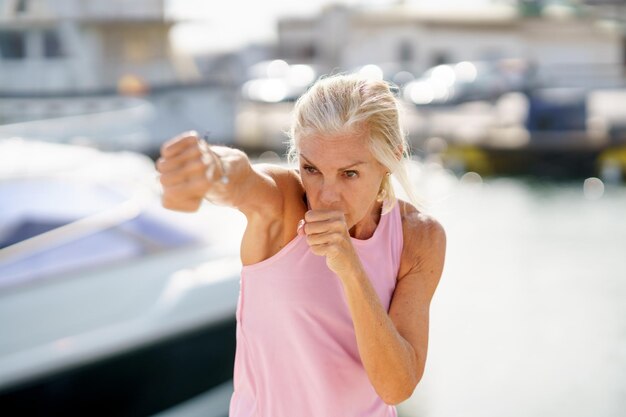 Foto portret van een vrouw die kickboxen in de open lucht