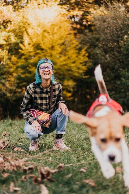 Portret van een vrouw die met een beagle-hond op het veld speelt