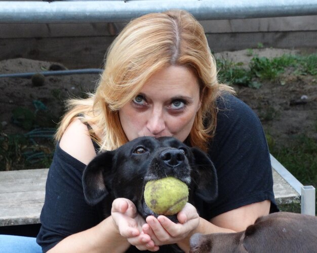 Foto portret van een vrouw die met honden speelt in het park