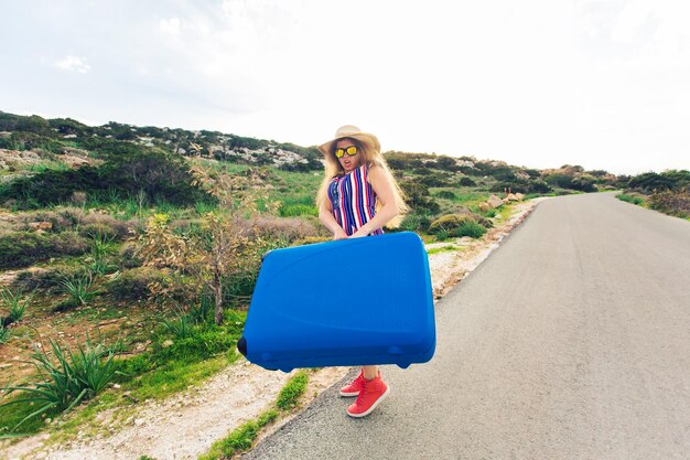 Portret van een vrouw die op de weg tegen de lucht staat