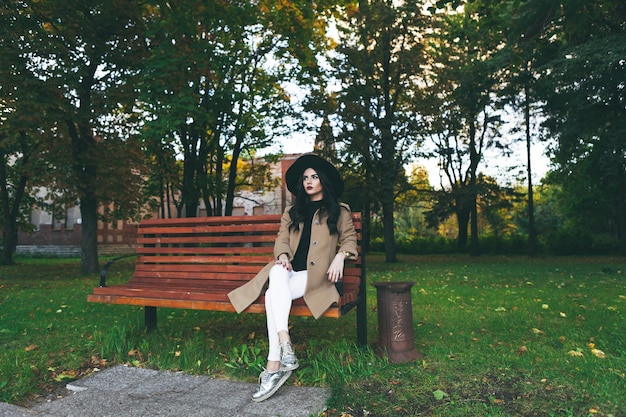 Portret van een vrouw die op een bankje in het park zit