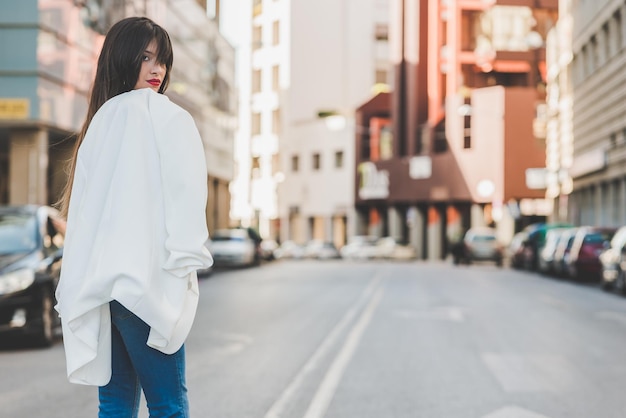 Portret van een vrouw die op een stadsstraat staat