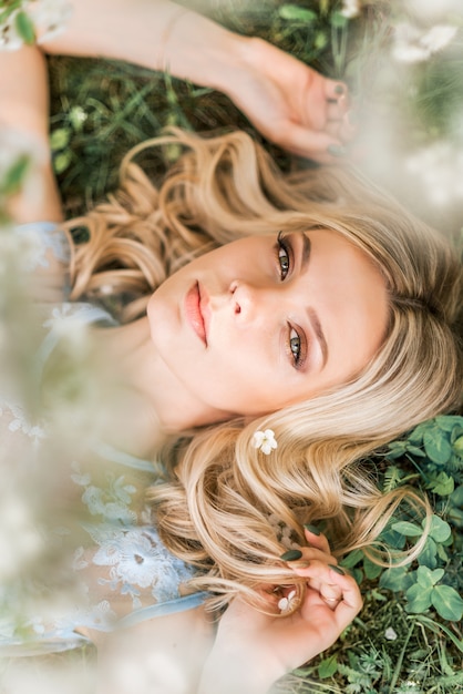 Portret van een vrouw die op het gras in de lente ligt