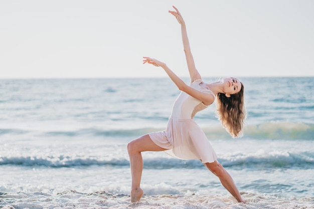 Portret van een vrouw die op het strand tegen de lucht danst