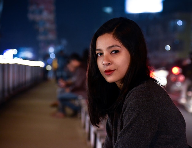 Portret van een vrouw die's nachts buiten staat
