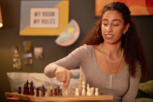 Portret van een vrouw die schaak speelt in een gezellige kamer