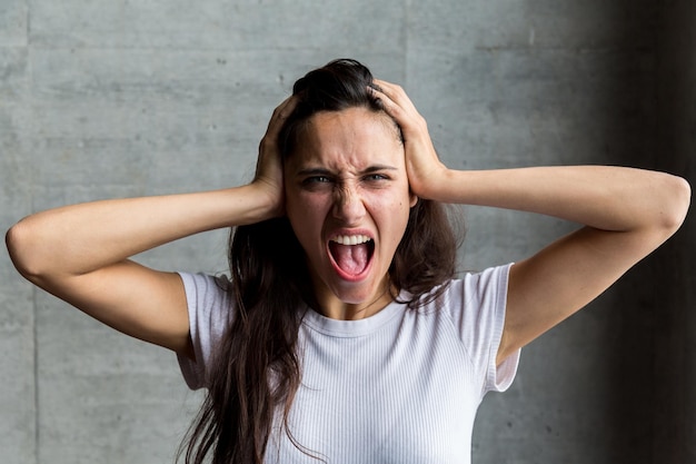 Portret van een vrouw die tegen de muur schreeuwt