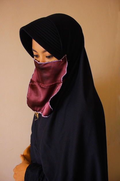 Portret van een vrouw die tegen de muur staat