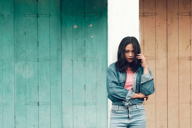 Portret van een vrouw die tegen de muur staat