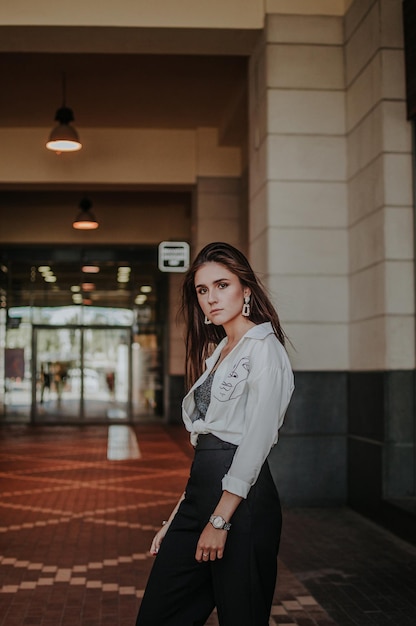 Portret van een vrouw die tegen de muur staat