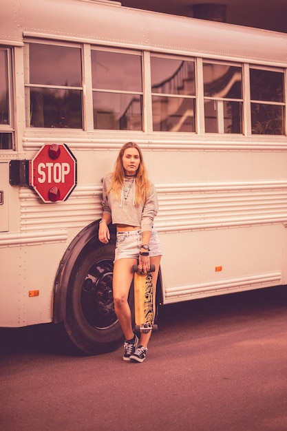 Foto portret van een vrouw die tegen een bus staat