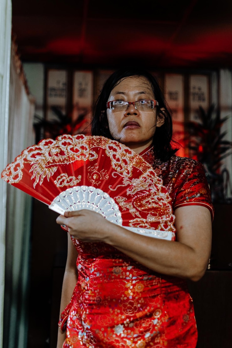 Foto portret van een vrouw die tegen een rode muur staat