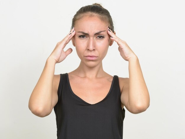 Foto portret van een vrouw die tegen een witte achtergrond staat