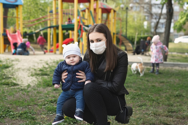 Portret van een vrouw en haar zoon in een beschermend masker tegen het kroonvirus of een uitbraak van het covid-19 en pm 2.5-virus in de stad