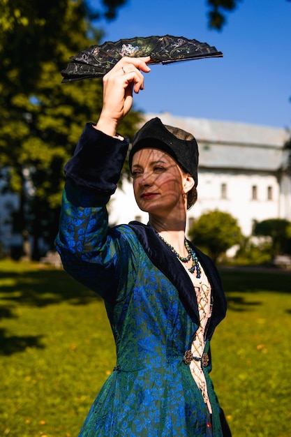 Portret van een vrouw gekleed in blauwe historische barokke kleding met ouderwets kapsel buitenshuis