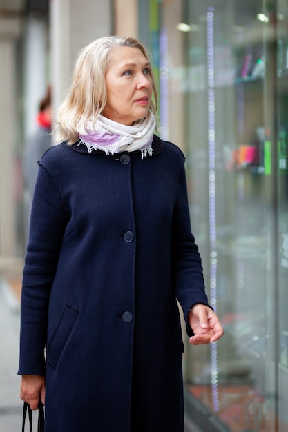 Portret van een vrouw in de buurt van etalage.