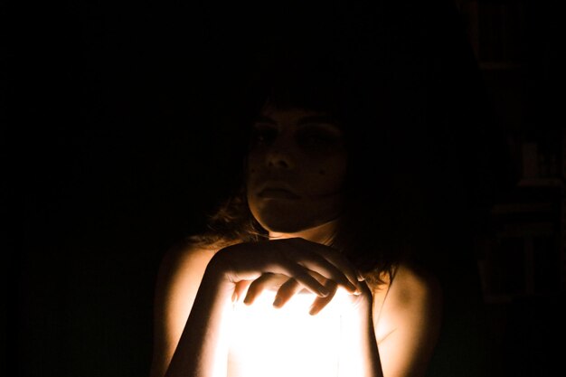 Foto portret van een vrouw in de donkere kamer