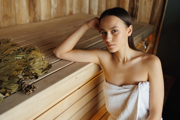 Portret van een vrouw in een handdoek in de sauna
