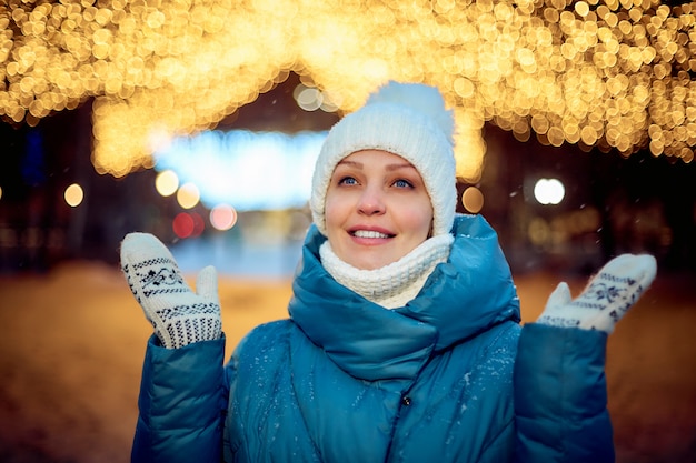 Portret van een vrouw in een winterpark in de avond, kerstversiering, toerisme en reizen.