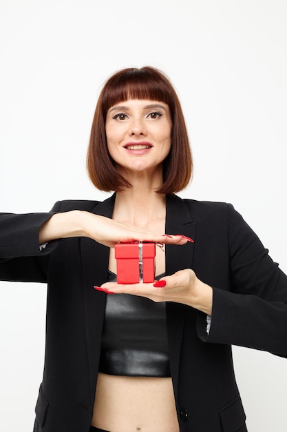 Portret van een vrouw in een zwarte jas rode nagellak vakantie cadeau lichte achtergrond