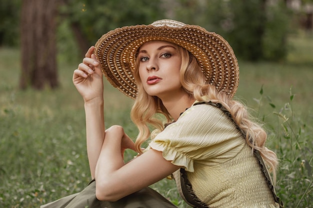 Portret van een vrouw met blond haar in retro kleding in een park of tuin