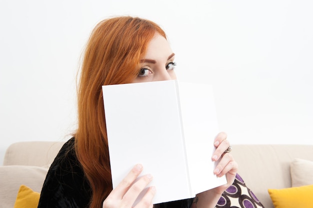 Foto portret van een vrouw met een boek op de bank